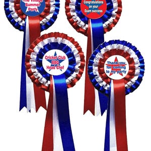 May include: Four circular award rosettes featuring red, white, and blue pleated ribbon borders. Each rosette has three long hanging ribbon tails in matching colours and a central disc with text: The Village Summer Party, Congratulations on your Exam success, Cricket Club BBQ Head Chef, and Thank you for coming to my party.