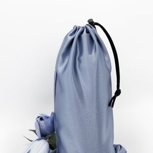Dusky denim blue satin bag with paracord drawstring and plastic toggle.