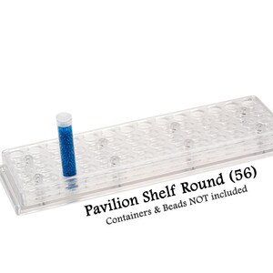May include: A clear plastic bead storage shelf with 56 compartments. The shelf is labeled "Pavilion Shelf Round (56)" and "Containers & Beads NOT included". A small clear tube filled with blue beads is sitting on the shelf.