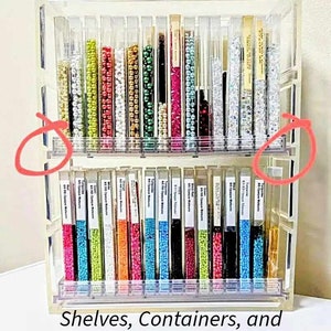 May include: A clear acrylic bead storage organizer with two shelves. The organizer has multiple compartments for storing beads. The shelves are labeled with the text "80 Opaque Matte".