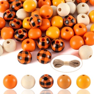 May include: A collection of wooden beads in orange, white, and black buffalo plaid patterns. The beads are strung on twine for crafting projects.