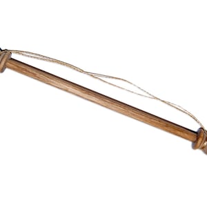 May include: A wooden dowel rod with rounded ends and a gold cord attached. The rod is used for hanging fabric or other items.