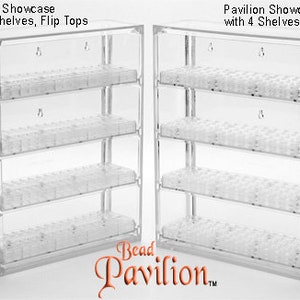 May include: Two clear plastic bead storage organizers with four shelves each. The organizer on the left has flip tops, while the organizer on the right has round tops. Both organizers are labeled "Pavilion Showcase with 4 Shelves".