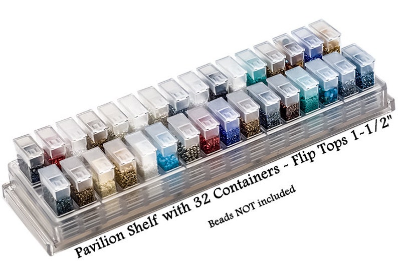 May include: A clear plastic storage organizer featuring a pavilion shelf with 32 individual containers, each equipped with a flip top lid. The text on the base reads Pavilion Shelf with 32 Containers ~ Flip Tops 1-1/2" and Beads NOT included.
