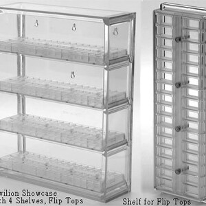 May include: A clear acrylic Pavilion Showcase featuring four horizontal shelves with individual flip-top compartments. The unit includes wall-mounting keyhole slots on the back panel. A separate vertical shelf unit for flip-top containers is also shown.