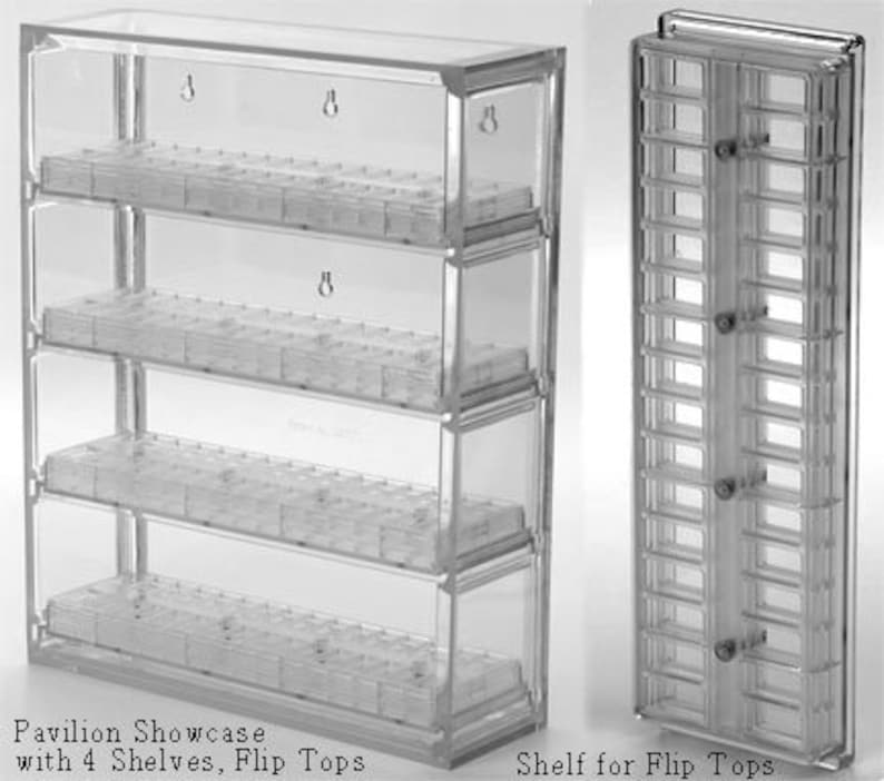 May include: A clear acrylic Pavilion Showcase featuring four horizontal shelves with individual flip-top compartments. The unit includes wall-mounting keyhole slots on the back panel. A separate vertical shelf unit for flip-top containers is also shown.