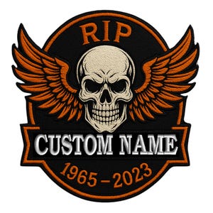 Könnte beinhalten: Schwarzer und orangefarbener gestickter Patch mit einem Schädel mit Flügeln, dem Text "RIP" über dem Schädel und dem Text "CUSTOM NAME 1965-2023" unter dem Schädel.