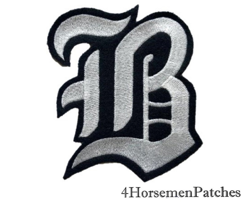 Puede incluir: Un parche de hierro bordado en plata y negro de la letra "B" en una fuente g&oacute;tica. El parche mide aproximadamente 7,6 cm de alto y 5 cm de ancho. 4HorsemenPatches est&aacute; impreso debajo del parche.