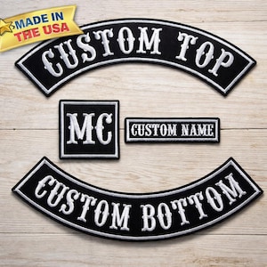 May include: A collection of black and white embroidered patches. The set includes two curved patches with "CUSTOM TOP" and "CUSTOM BOTTOM", a square patch with "MC", and a rectangular patch with "CUSTOM NAME". A gold banner reads "MADE IN THE USA".