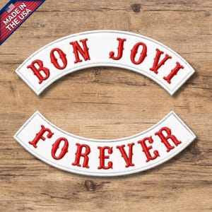 May include: Two curved embroidered patches with white backgrounds and red stitched lettering. The top patch features the text BON JOVI in a bold serif font, while the bottom patch displays the word FOREVER in the same matching red font style.