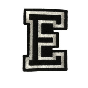 May include: Black felt letter E with a white outline. The letter is in a varsity style font.