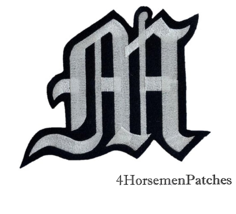 Puede incluir: Parche de hierro bordado en blanco y negro de la letra "M" en estilo de fuente g&oacute;tica.