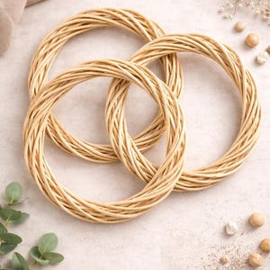 May include: Three circular wreaths made from woven, light brown twigs, intertwined to create a decorative pattern. The natural colour and texture of the wreaths give them a rustic appearance, suitable for crafting or home decoration.