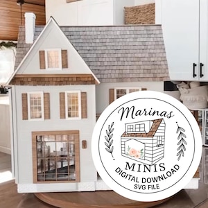 Könnte beinhalten: Ein Miniatur-Puppenhaus mit grauem Schindeldach, hellblauen Seitenwänden und braunen Zierleisten. Das Puppenhaus hat mehrere Fenster und eine große Eingangstür. Ein rundes Logo mit dem Text "Marinas Minis Digital Download SVG File" befindet sich im Vordergrund.