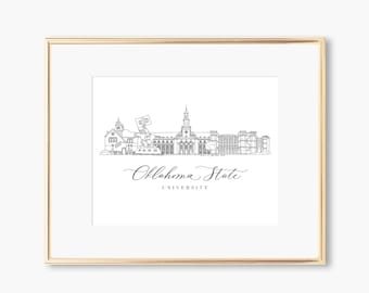 May include: A framed black and white line drawing of the Oklahoma State University campus skyline. The artwork is in a gold frame and features the university's name in elegant script below the buildings.