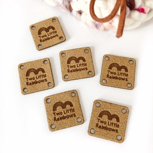 May include: Six brown leather labels with the text "Two Little Rainbows" and a rainbow graphic. The labels have four holes each.