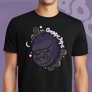 May include: A black t-shirt with a purple gorilla head graphic and the text "Grape Ape" in a white circle. The gorilla has a white cross on its forehead and is surrounded by white stars and a crescent moon.