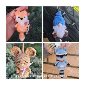 May include: Four crocheted amigurumi keychains: a fox with a pink flower, a gnome with a blue hat and white beard, a mouse with pink ribbon, and a raccoon with a red bow. The keychains are displayed on a variety of backgrounds, including a green tree, a black backpack, and a brick wall. The image includes the text "Patterns by Violets & Heather".