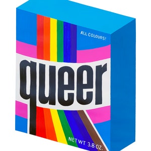 May include: A blue box with the word "queer" in bold black letters. The box has a rainbow stripe and the text "ALL COLORS!" and "NET WT 3.8 OZ."