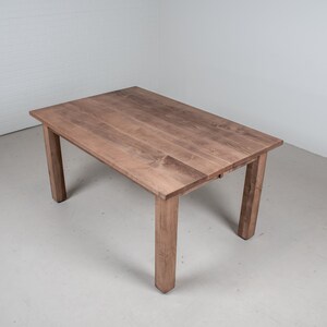 May include: A rectangular wooden table with a light brown finish. The table has four legs and a simple design.