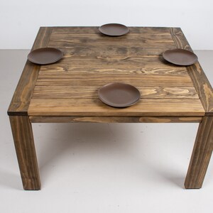 square outdoor dining table made with accoya wood on parson style base