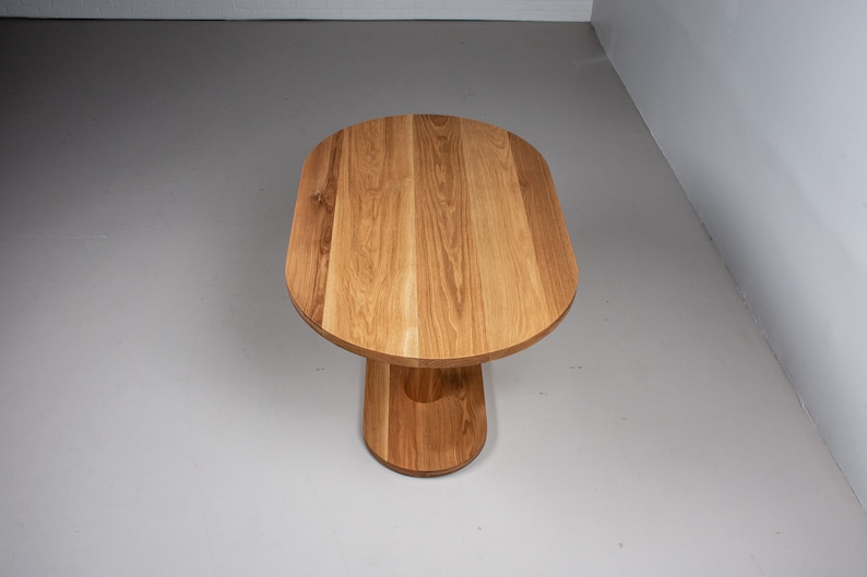 small oval kitchen table made of oak on pedestal base