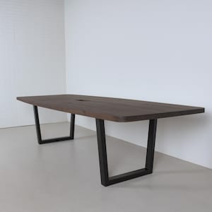 May include: A rectangular wooden table with a dark brown finish. The table has a recessed center and is supported by black metal legs. The table is approximately 96 inches long and 40 inches wide.