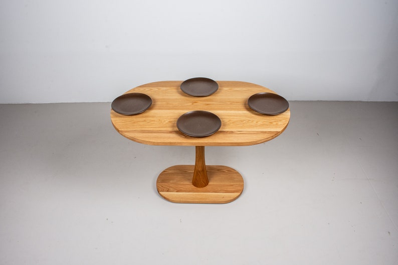 small oval kitchen table made of oak on pedestal base