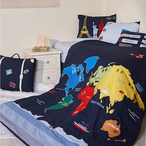 Puede incluir: Un juego de cama azul marino con un diseño de mapa del mundo colorido. El juego de cama incluye almohadas con monumentos icónicos como la Torre Eiffel y la Estatua de la Libertad. También hay una almohada con forma de maleta.