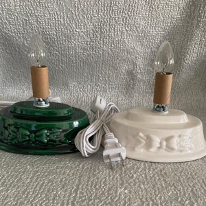 May include: Two ceramic Christmas tree bases, one green and one white, with light bulbs and cords.
