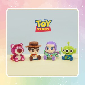 Puede incluir: Cuatro figuras pixeladas y coloridas de personajes de Toy Story: Lotso, Woody, Buzz Lightyear y un Alien. El logotipo de Toy Story se muestra encima de las figuras. Las figuras están sobre un fondo azul claro.
