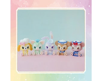 May include: Five small, colourful, beaded figurines of cartoon characters. The characters are a yellow dog, a green cat, a purple bunny, a brown bear, and a pink bear. Each character is wearing a hat and has a different expression.