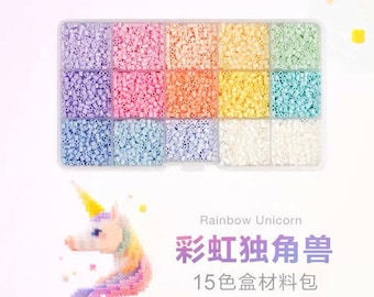 May include: A clear plastic container filled with 15 different colors of small plastic beads. The beads are arranged in rows and columns. The container is labeled "Rainbow Unicorn 15 色 盒 材料 色".