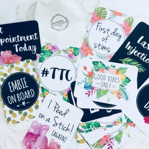 Pode incluir: Um conjunto de 10 cart&otilde;es de an&uacute;ncio de gravidez com designs florais tropicais e texto preto e branco. Os cart&otilde;es incluem frases como "#TTC", "Primeiro dia de estimula&ccedil;&atilde;o", "Somente boas vibra&ccedil;&otilde;es" e "Fiz um teste de gravidez! (de novo)".