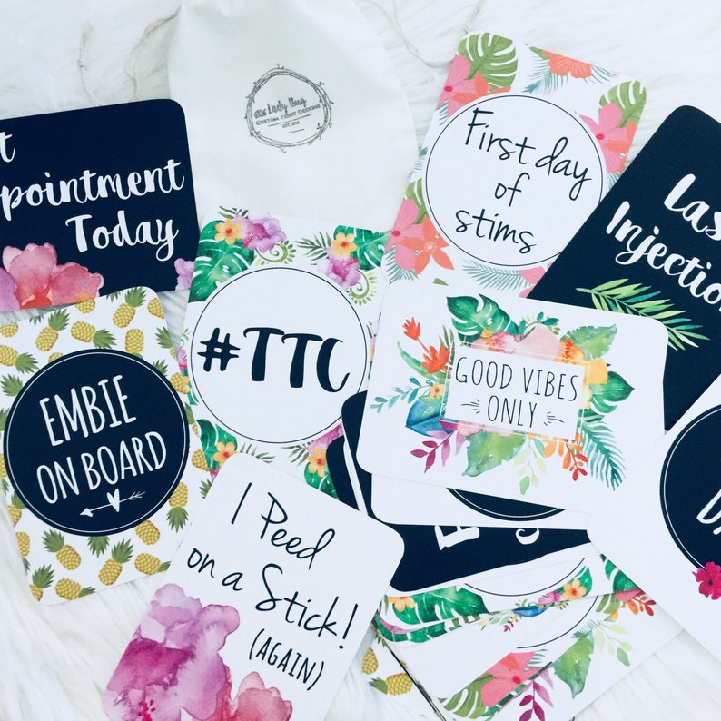 Pode incluir: Um conjunto de 10 cart&otilde;es de an&uacute;ncio de gravidez com designs florais tropicais e texto preto e branco. Os cart&otilde;es incluem frases como "#TTC", "Primeiro dia de estimula&ccedil;&atilde;o", "Somente boas vibra&ccedil;&otilde;es" e "Fiz um teste de gravidez! (de novo)".