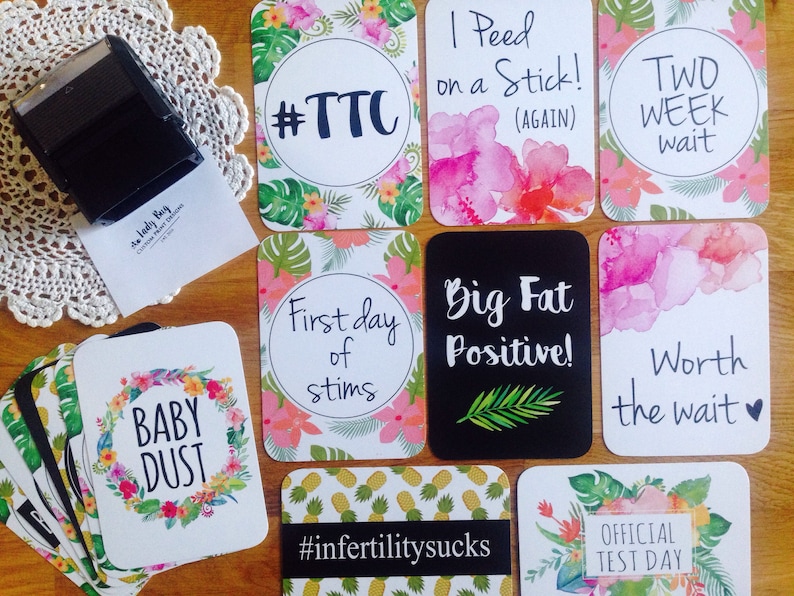 Pode incluir: Um conjunto de 10 cart&otilde;es com designs florais tropicais e texto relacionado &agrave; fertilidade e gravidez. Os cart&otilde;es incluem frases como "#TTC", "Primeiro dia de estimula&ccedil;&atilde;o", "Grande Positivo!" e "Vale a pena esperar".