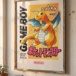 Puede incluir: Póster enmarcado de estilo vintage con un Dragonite amarillo de Pokémon. El póster tiene texto japonés y el logotipo de Game Boy. La obra de arte está sobre un fondo amarillo con detalles en azul y está enmarcada en un marco de madera.