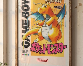 May include: Framed vintage-style poster featuring a yellow Dragonite from Pokémon. The poster has Japanese text and the Game Boy logo. The artwork is set against a yellow background with blue accents and is framed in a wooden frame.