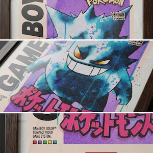 May include: Framed print featuring a Gengar Pok&eacute;mon illustration. The artwork has a purple and blue colour scheme with Japanese text and the Nintendo logo. The print is framed in a dark brown wooden frame.