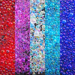 May include: A close-up of five vertical strips of iridescent beads. The beads are red, purple, white, blue, and dark blue.
