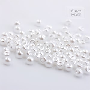 May include: A pile of 6mm white pearl buttons.