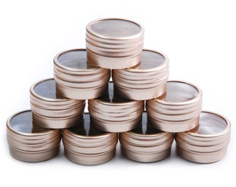 May include: A stack of ten gold metal containers with clear lids. The containers are arranged in a pyramid shape.
