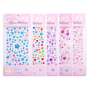 Puede incluir: Cinco hojas de pegatinas de gemas de colores. Cada hoja presenta un diseño diferente de gemas, incluyendo flores, estrellas y círculos. Las pegatinas son perfectas para agregar un toque de brillo a las manualidades, tarjetas y otros proyectos.