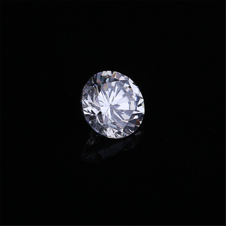 Pu&ograve; includere: Un grande diamante rotondo e trasparente con molte sfaccettature.