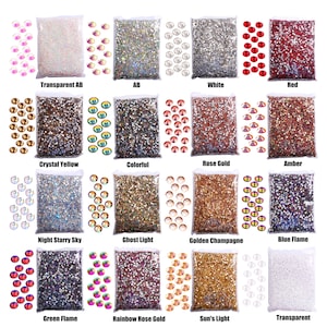 May include: Assortment of 16 bags of colorful rhinestones, each bag labeled with a different color name, such as "Transparent AB", "AB", "White", "Red", "Crystal Yellow", "Colorful", "Rose Gold", "Amber", "Night Starry Sky", "Ghost Light", "Golden Champagne", "Blue Flame", "Green Flame", "Rainbow Rose Gold", "Sun's Light", and "Transparent".