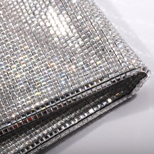 May include: A silver mesh fabric with a square pattern. The fabric is folded over on itself, showing the underside of the mesh.