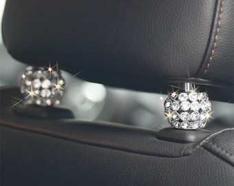Puede incluir: Dos cubiertas de reposacabezas de coche plateadas con un diseño de diamantes brillantes.