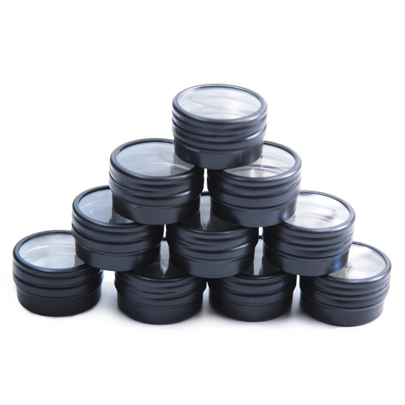 May include: A stack of ten black metal containers with clear lids. The containers are arranged in a pyramid shape.