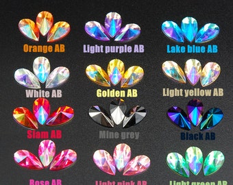 May include: A collection of iridescent teardrop-shaped rhinestones in various colors, including orange, light purple, lake blue, white, golden, light yellow, siam, mine grey, black, rose, light pink, and light green. Each group is labeled with its color name and "AB".