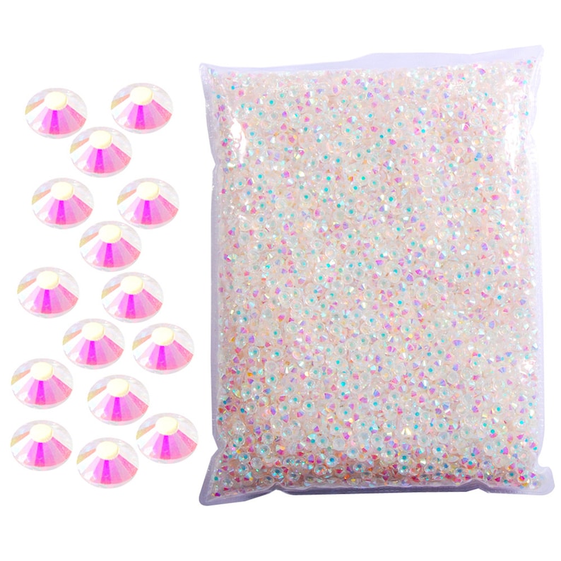 May include: A bag of iridescent white rhinestones with a sample of 15 rhinestones on a white background.